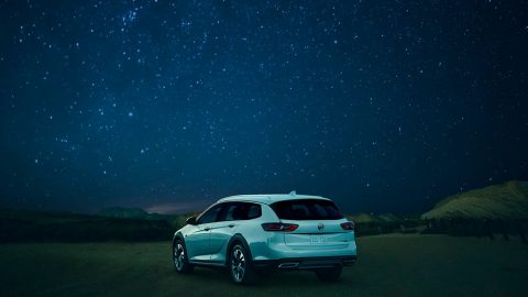 SUV blanco bajo una noche estrellada después de un paseo nocturno