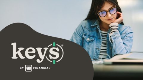 Female student looks down at book while studying with KEYS Online logo overlayed